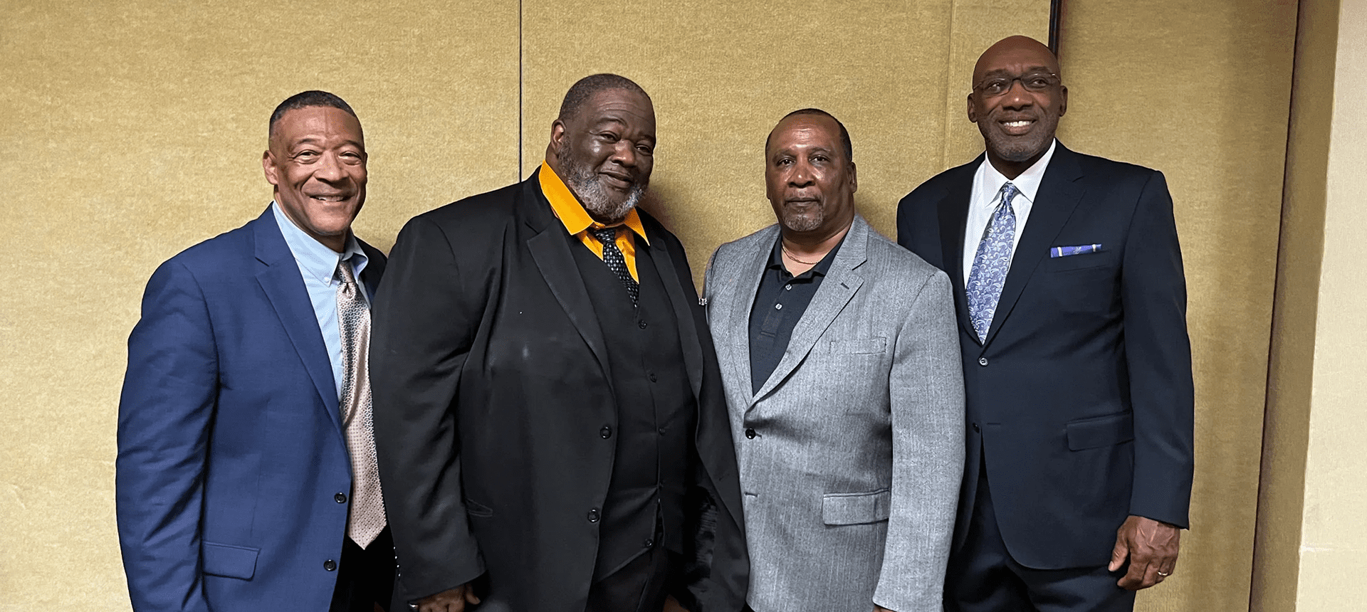 Group photo of four smiling men